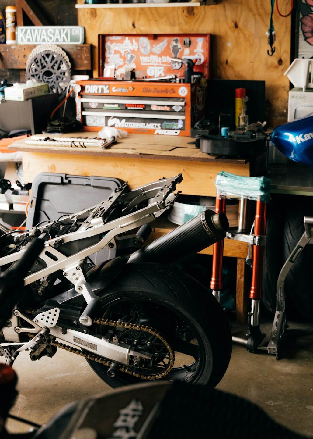Motorradrahmen und Hinterrad in einer Werkstattgarage.